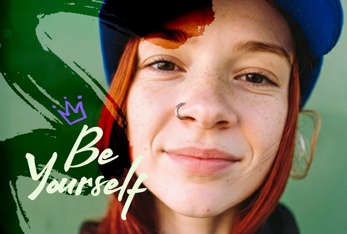 Portrait of a smiling young woman with red hair and freckles, wearing a blue cap, with green and black brushstroke overlays, a purple hand-drawn crown, and the text Be Yourself in cream script.